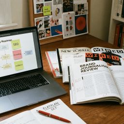 Mesa de trabajo de editor con revistas impresas y laptop, concepto de estrategia de contenidos
